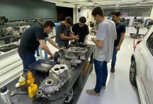 Instrutor e alunos em uma bancada manipulando um motor