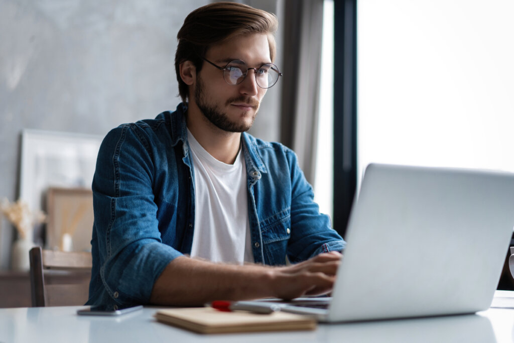 Homem sentado estudando com computador