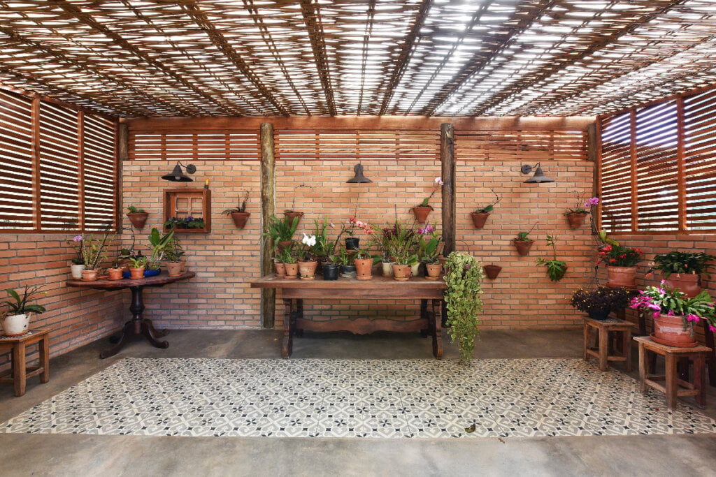 espaço com paredes de madeira e mesas de madeira com vasos de plantas