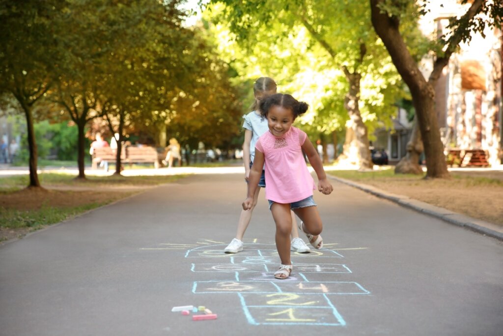 duas meninas brincando de amarelinha na rua