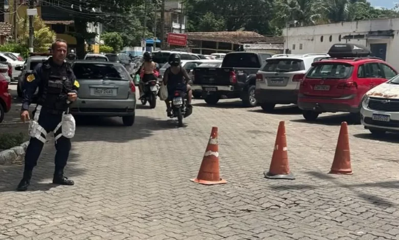 Agente de trânsito monitora a circulação de veículos em área com bloqueios e restrições de estacionamento