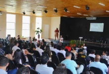 Pessoas sentadas num auditório assistindo a uma palestra
