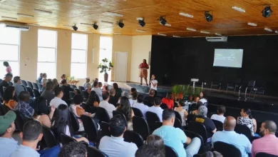 Pessoas sentadas num auditório assistindo a uma palestra