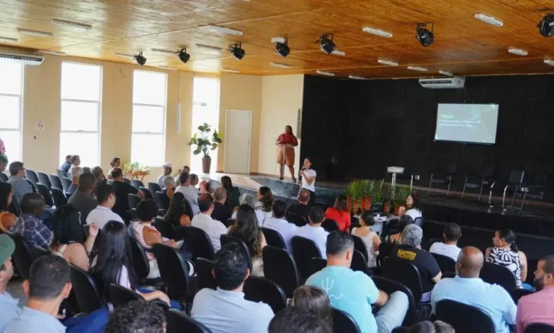 Pessoas sentadas num auditório assistindo a uma palestra