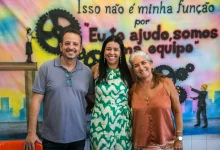 Três pessoas sorridentes posando para uma foto