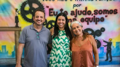 Três pessoas sorridentes posando para uma foto