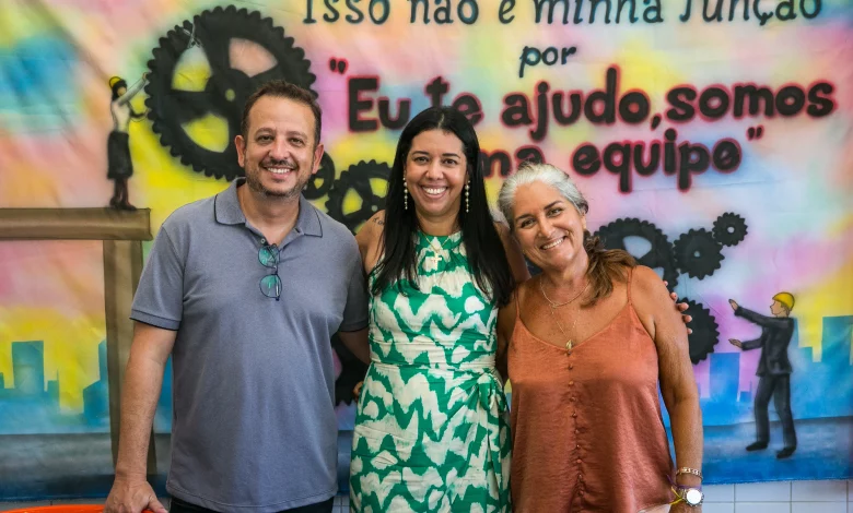 Três pessoas sorridentes posando para uma foto