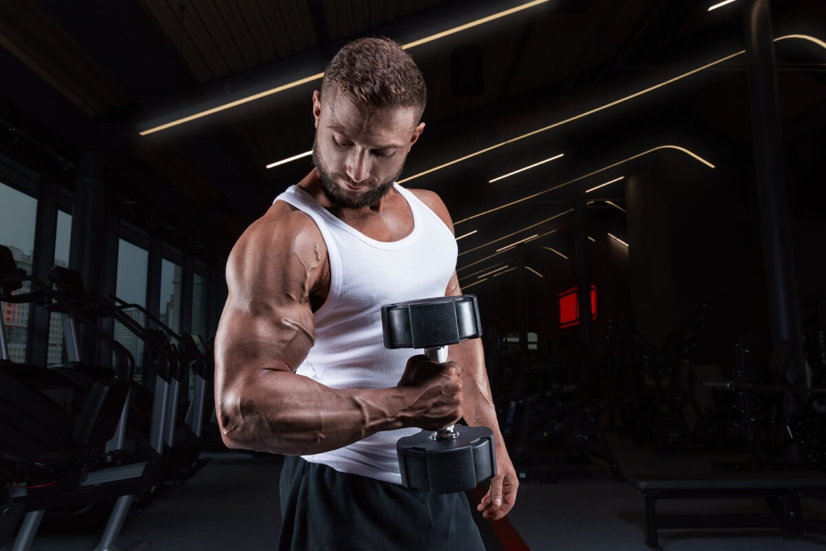 Homem segurando um halter em uma academia 