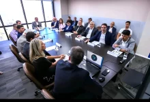 Na foto, em torno de uma mesa oval, autoridades, representantes empresariais e especialistas debatem estratégias para incentivar a sustentabilidade e o desenvolvimento econômico nos municípios litorâneos