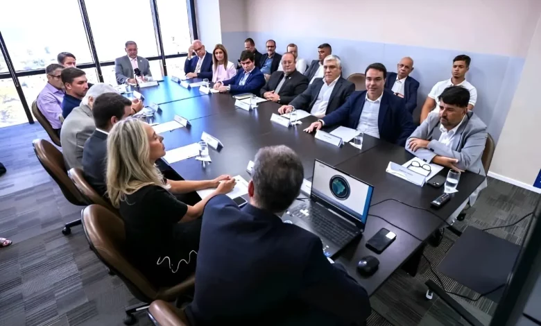 Na foto, em torno de uma mesa oval, autoridades, representantes empresariais e especialistas debatem estratégias para incentivar a sustentabilidade e o desenvolvimento econômico nos municípios litorâneos