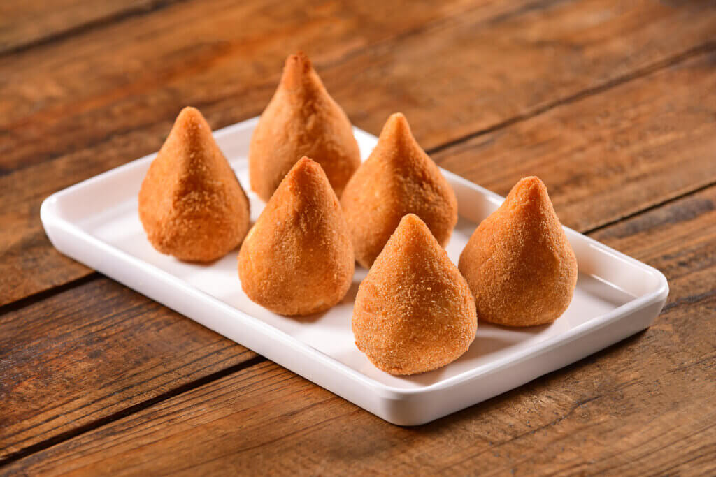 Seis coxinhas em recipiente branco