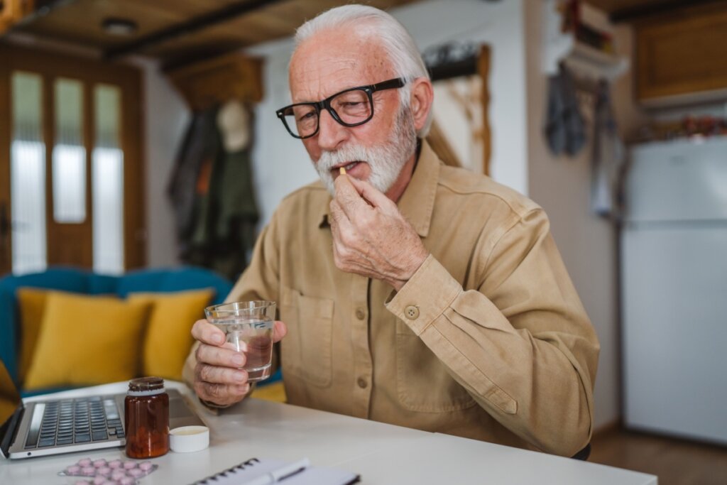 Homem idoso tomando remédio