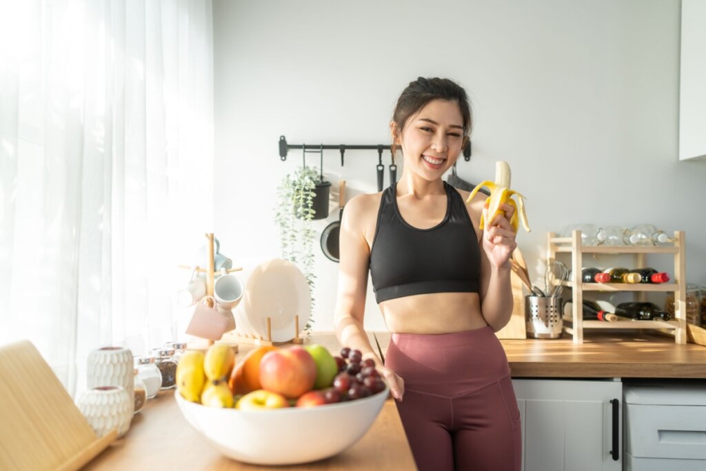 Mulher comendo banana  após realizar exercício físico