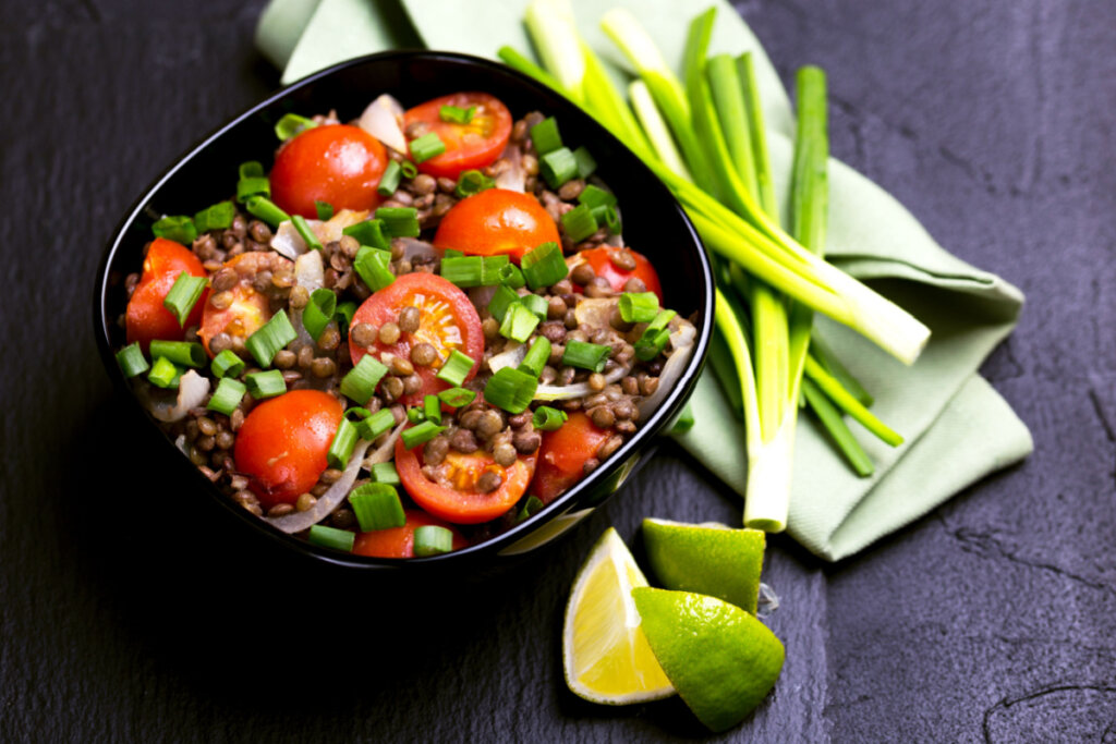 pote preto com salada de lentilha, tomate-cereja e cebola