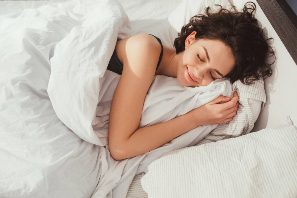 Mulher deitada com os olhos fechados sorrindo