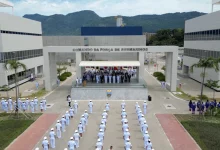 Marinha do Brasil expande Complexo Naval de Itaguaí - foto aérea mostra cerimonial. No primeiro plano, militares estão em posição de sentido enfileirado. No cenário, ao centro tem um portal com a inscrição "comando da força de submarinos" entre dois prédios administrativos, onde estão os militares de alta patente