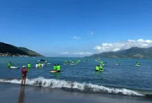 Os participantes do Circuito de Stand Up Paddle entram no mar da Praia do Saco