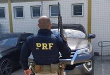 Agente da PRF em frente ao carro recuperado na Dutra