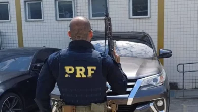 Agente da PRF em frente ao carro recuperado na Dutra