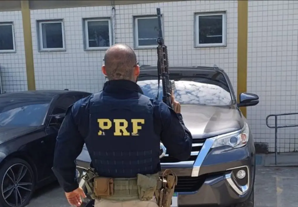 Agente da PRF em frente ao carro recuperado na Dutra