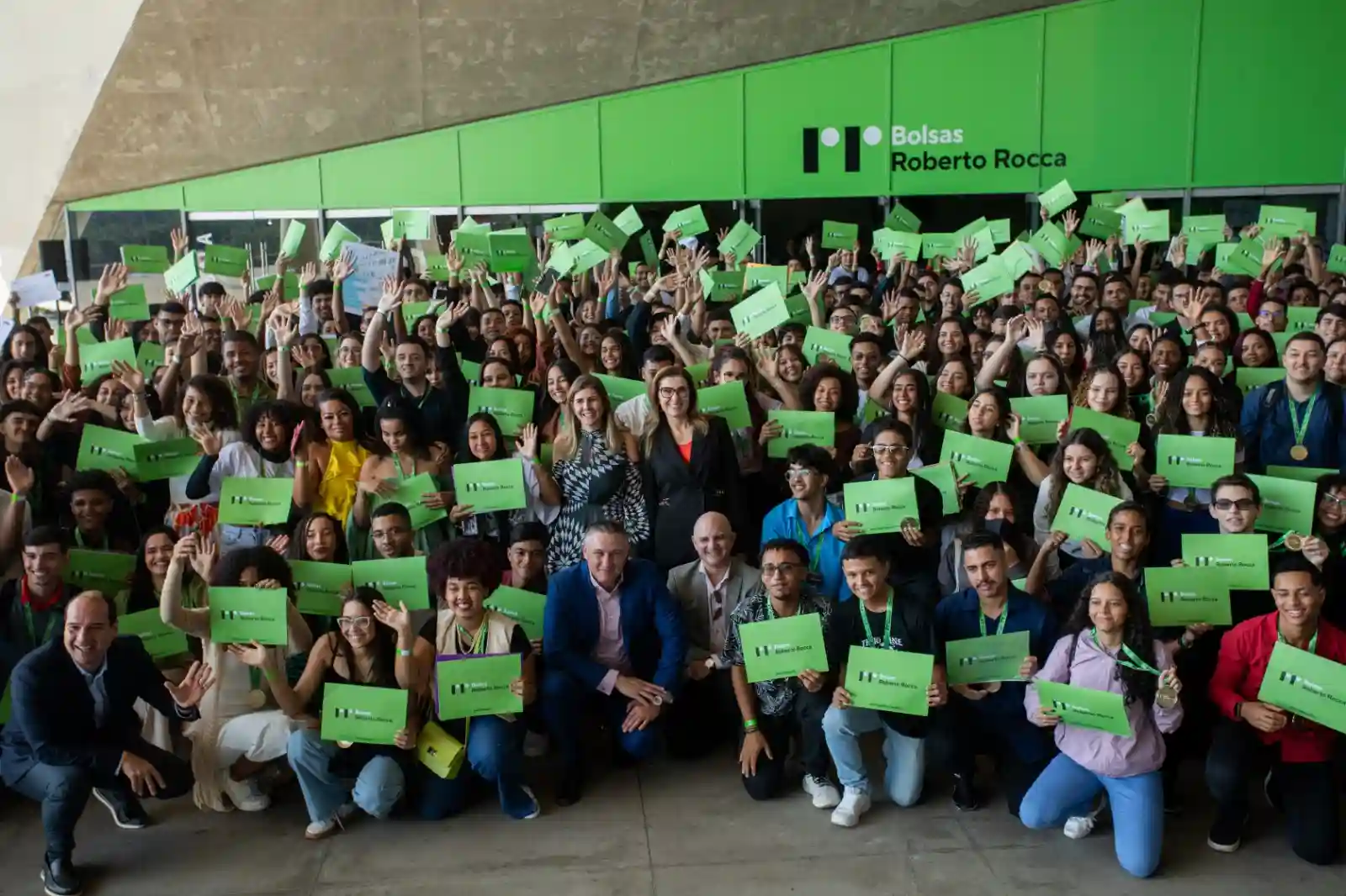 Ternium oferece bolsas / NA FOTO, diretoria da Ternium posa com dezenas de alunos segurando placa na cor verde com a inscrição Bolsas Roberto Rocca