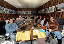 Várias pessoas sentadas à mesa com o prefeito de Mangaratiba