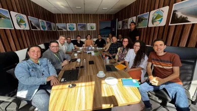 Várias pessoas sentadas à mesa com o prefeito de Mangaratiba