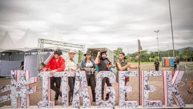 Participantes caracterizados em frente ao letreiro do Itageek