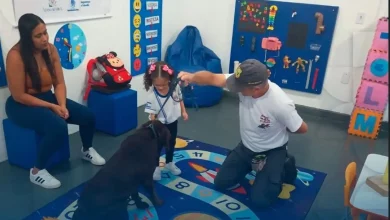 Profissional do Grupamento de Ações com Cães da Guarda Municipal de Mangaratiba orienta uma aluna durante atividade