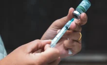 Profissional da saúde prepara dose da vacina contra a gripe.