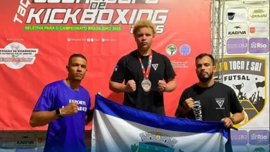 Atleta medalhista de bronze na Taça Guanabara de Kickboxing 2025, ao lado de sua equipe técnica.