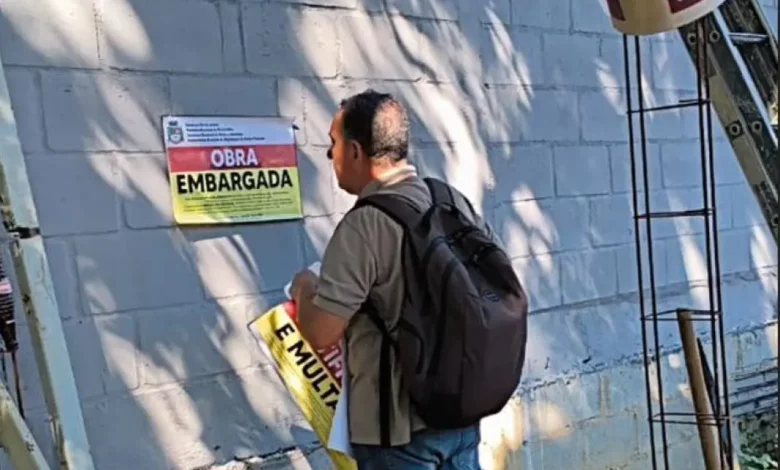 Agente da Prefeitura de Mangaratiba afixa aviso de embargo em construção irregular