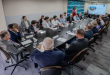 Representantes de portos e terminais sentados ao redor de uma longa mesa de reunião.