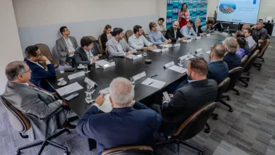 Representantes de portos e terminais sentados ao redor de uma longa mesa de reunião.
