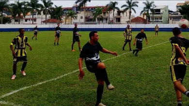 Jogadores disputam a bola em campo