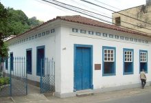 Fachada pintada em branco com detalhes azuis do Centro Cultural Cary Cavalcanti