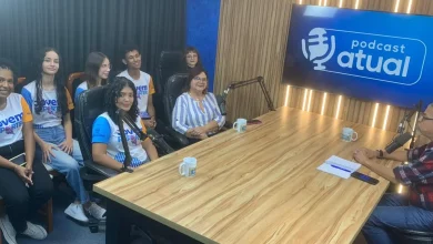 Alunos e diretora sentados à mesa com o entrevistador