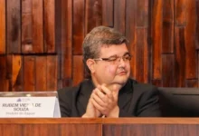 TRE notificado diplomação Rubão Rubão está em cerimônia, batendo palmas; ao seu lado direito, uma placa com sua identificação