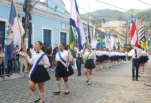 Estudantes desfilam com bandeiras durante celebração cívica em Mangaratiba