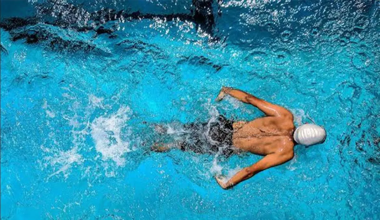 Homem nadando em piscina. Imagem ilustrativa da nova Escolinha de Natação de Mangaratiba, que oferece aulas gratuitas para crianças e adolescentes