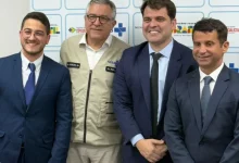 Quatro homens posando para foto sorrindo