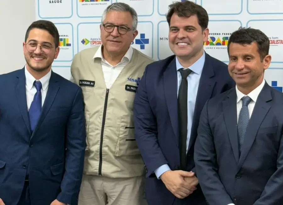 Quatro homens posando para foto sorrindo