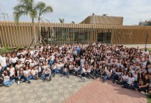 192 Alunos sentados em frente a fachada da escola