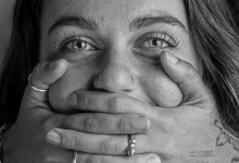 Mulher com a boca tampada