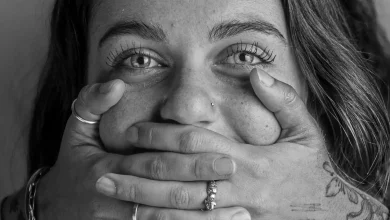 Mulher com a boca tampada