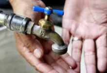 Morador verifica torneira seca durante interrupção no abastecimento de água