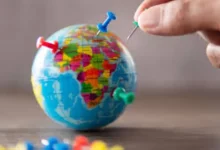 Globo terrestre com alfinetes coloridos representa a expansão internacional de negócios