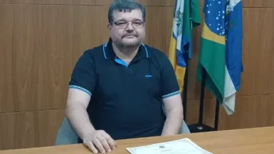 TSE vai decidir destino de Rubão: Na foto, rubão está sentado à mesa com diploma sobre ela. ao fundo, bandeiras da cidade, do estado e do país