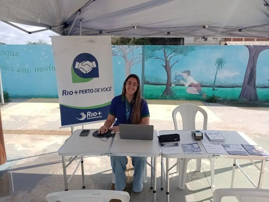 Funcionária da Rio+Saneamento realiza atendimento durante a ação itinerante