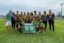 Equipe feminina da Liga Desportiva de Itaguaí posa em campo com a faixa de agradecimento